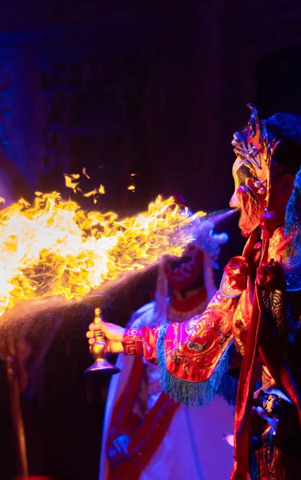Performer crachant du feu avec un masque coloré