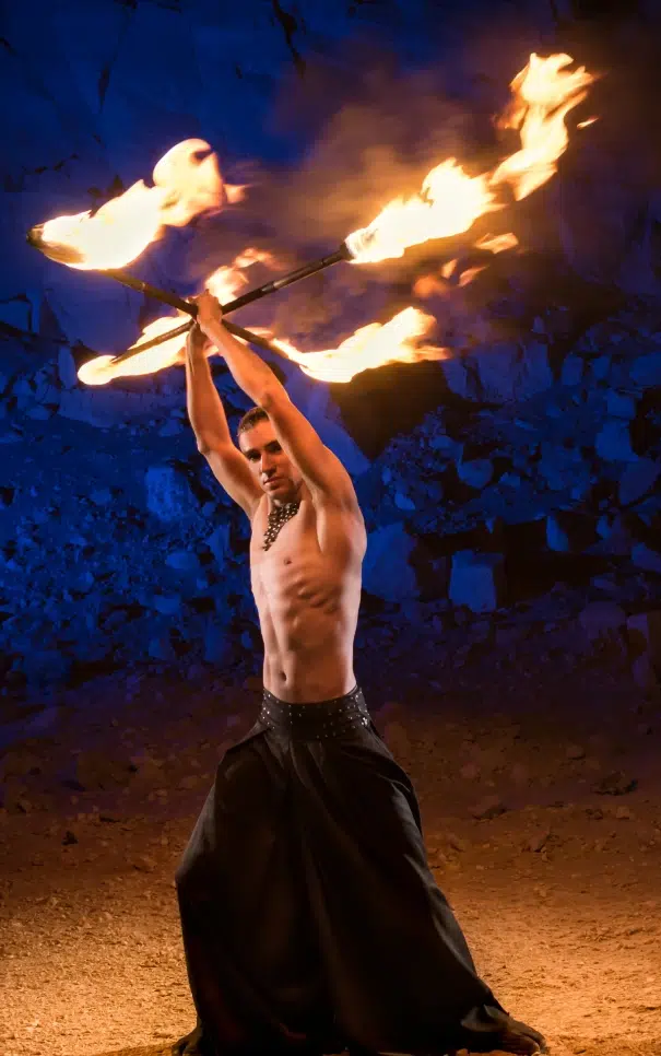 Homme jonglant avec des bâtons enflammés